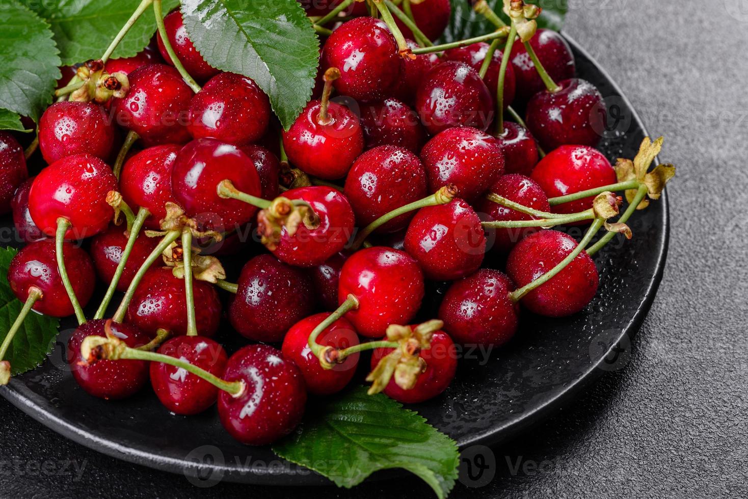 Frescas deliciosas bagas vermelhas brilhantes de cereja rasgadas no jardim de verão foto