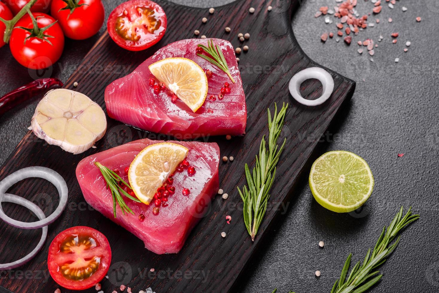 bifes de filé de atum fresco com especiarias e ervas em um fundo preto foto