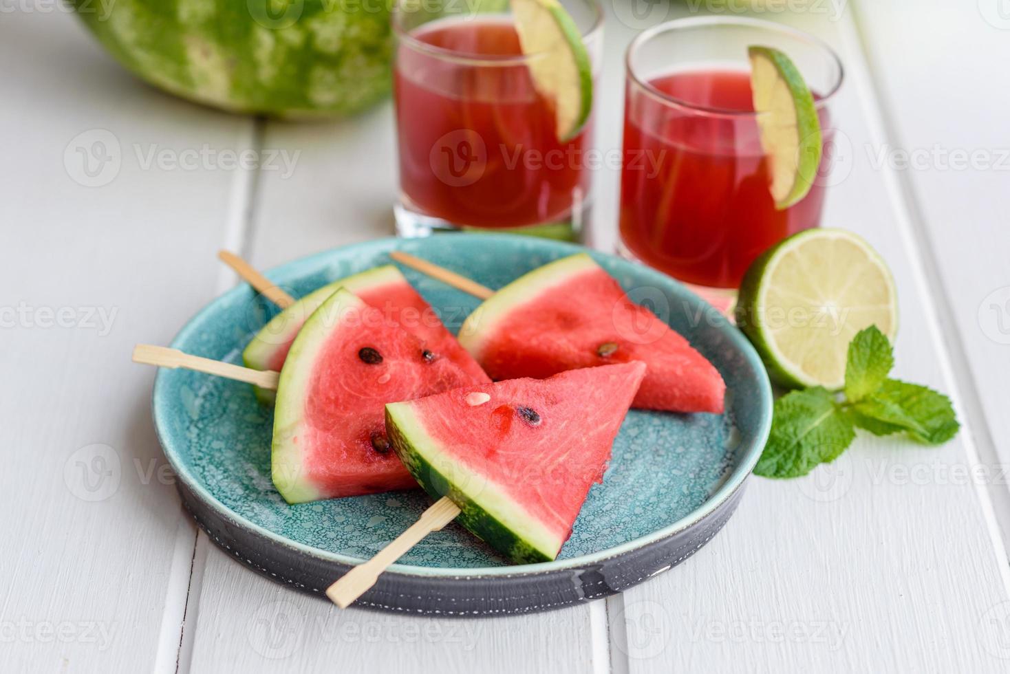 deliciosa melancia fatiada com hortelã e suco de melancia foto