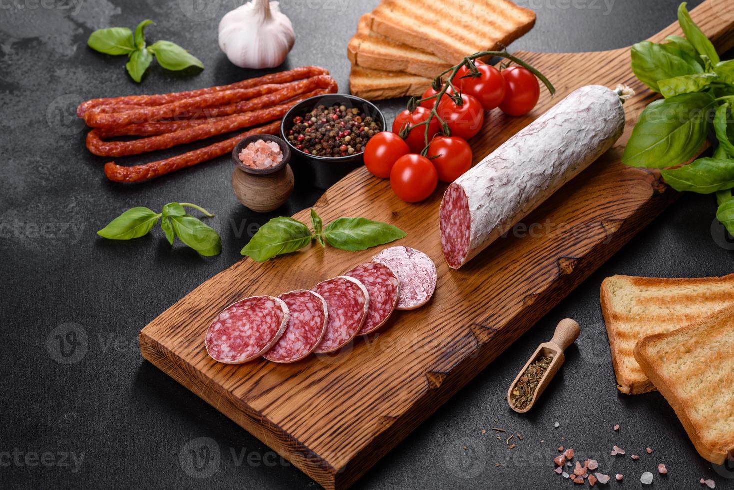 Salame de linguiça seca espanhola em um fundo escuro de concreto foto