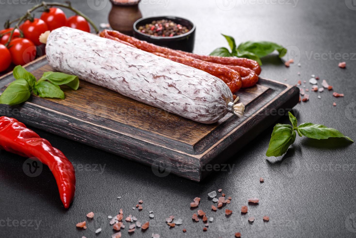 Salame de linguiça seca espanhola em um fundo escuro de concreto foto