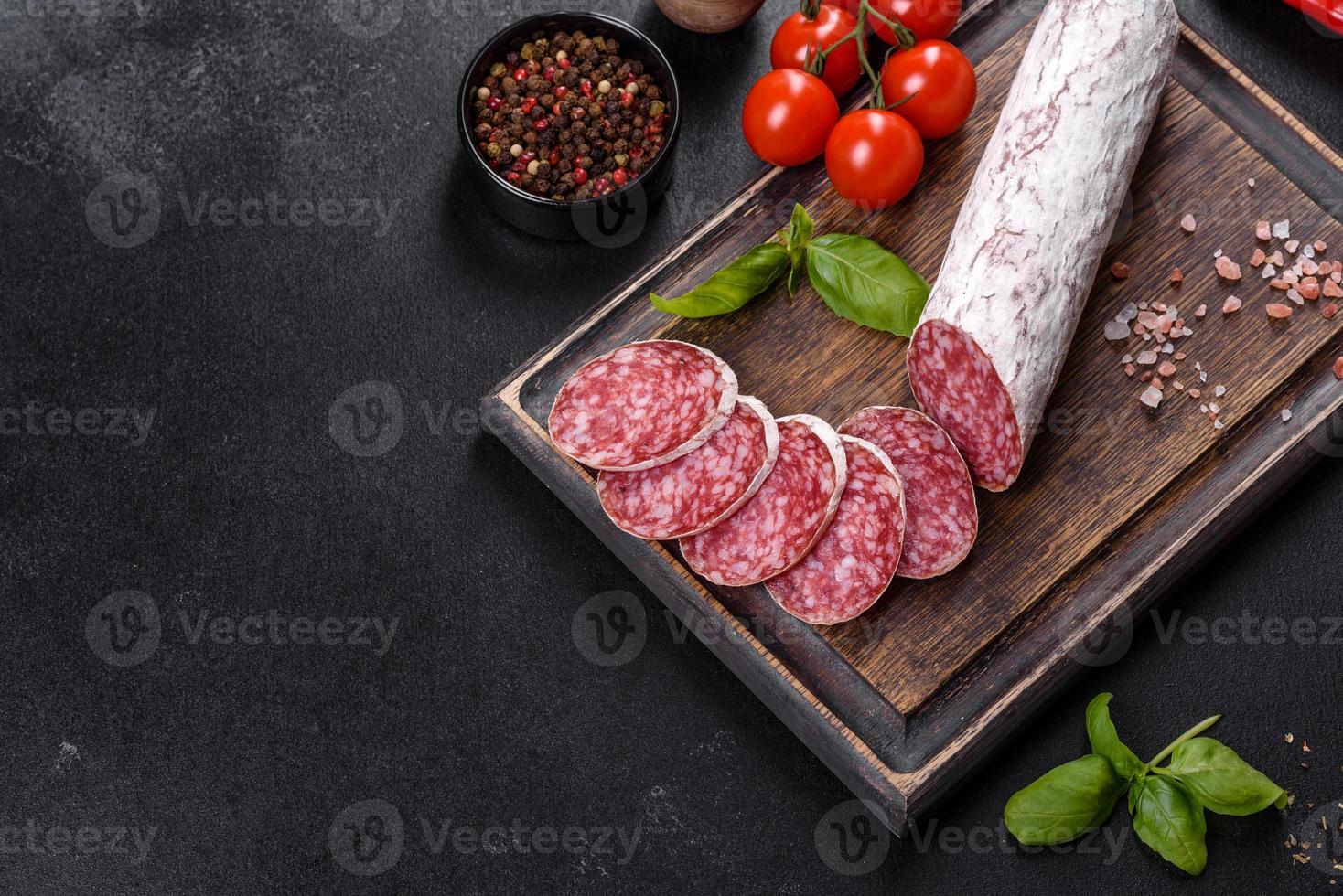 Salame de linguiça seca espanhola em um fundo escuro de concreto foto