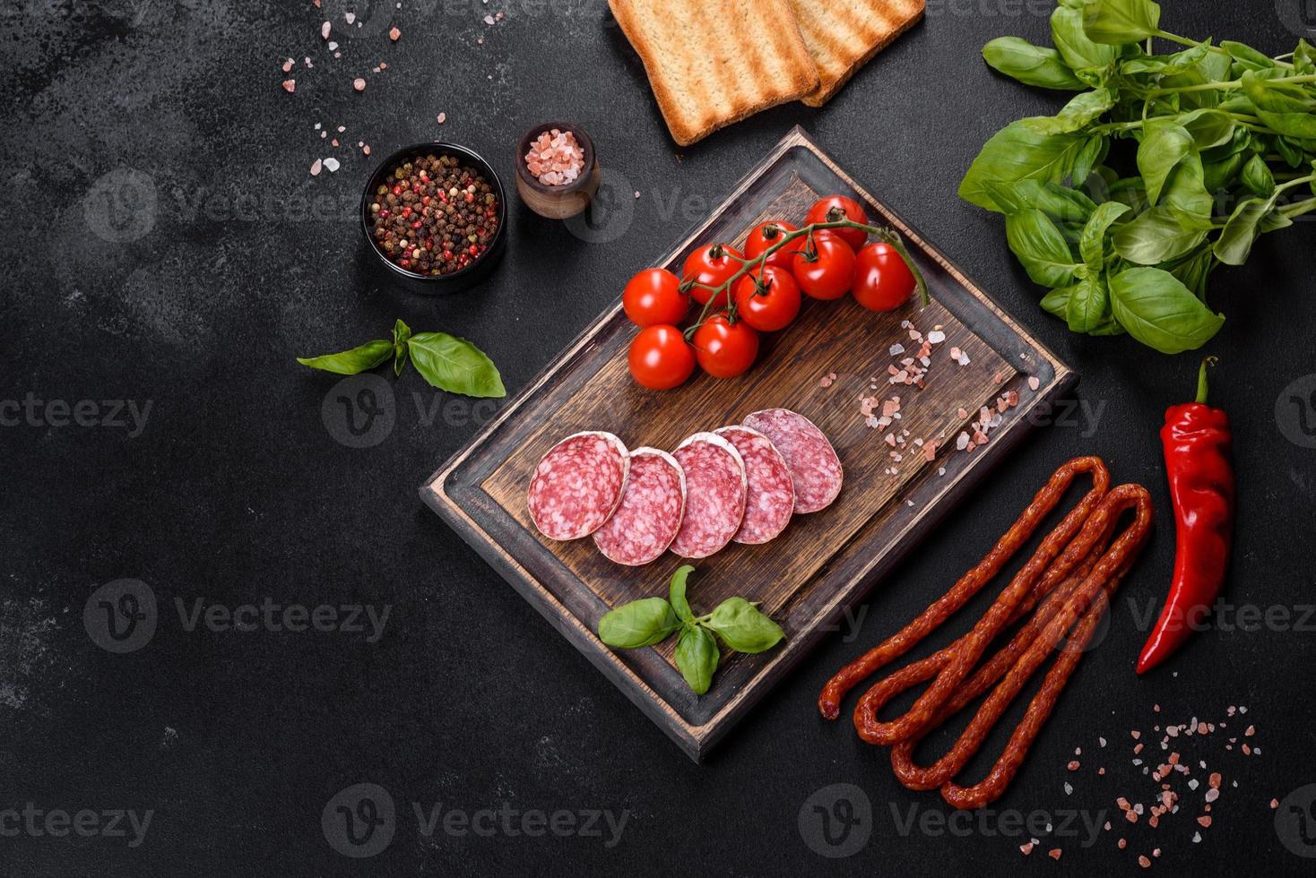 Salame de linguiça seca espanhola em um fundo escuro de concreto foto