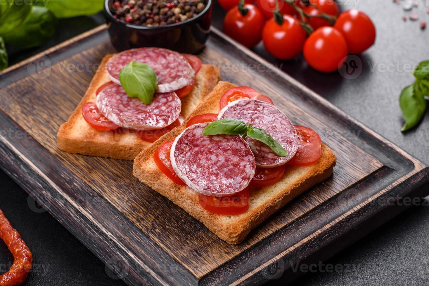 Salame de linguiça seca espanhola em um fundo escuro de concreto foto