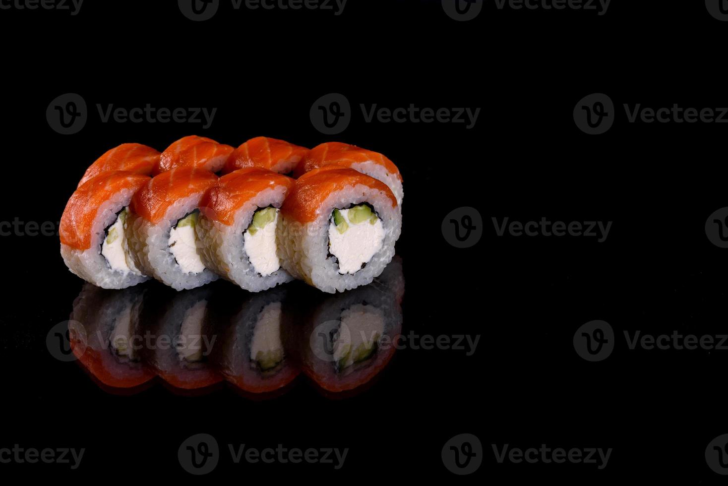 frescos deliciosos rolos de sushi bonitos em um fundo escuro foto