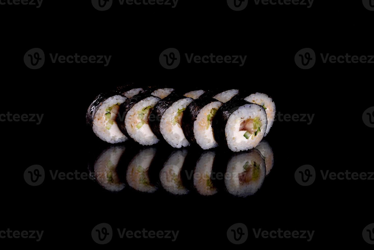 frescos deliciosos rolos de sushi bonitos em um fundo escuro foto