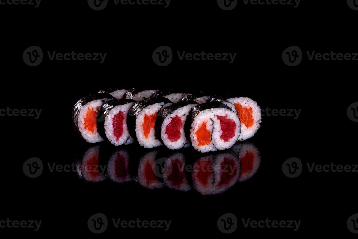 frescos deliciosos rolos de sushi bonitos em um fundo escuro foto