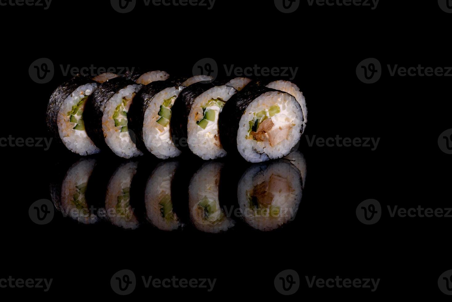 frescos deliciosos rolos de sushi bonitos em um fundo escuro foto