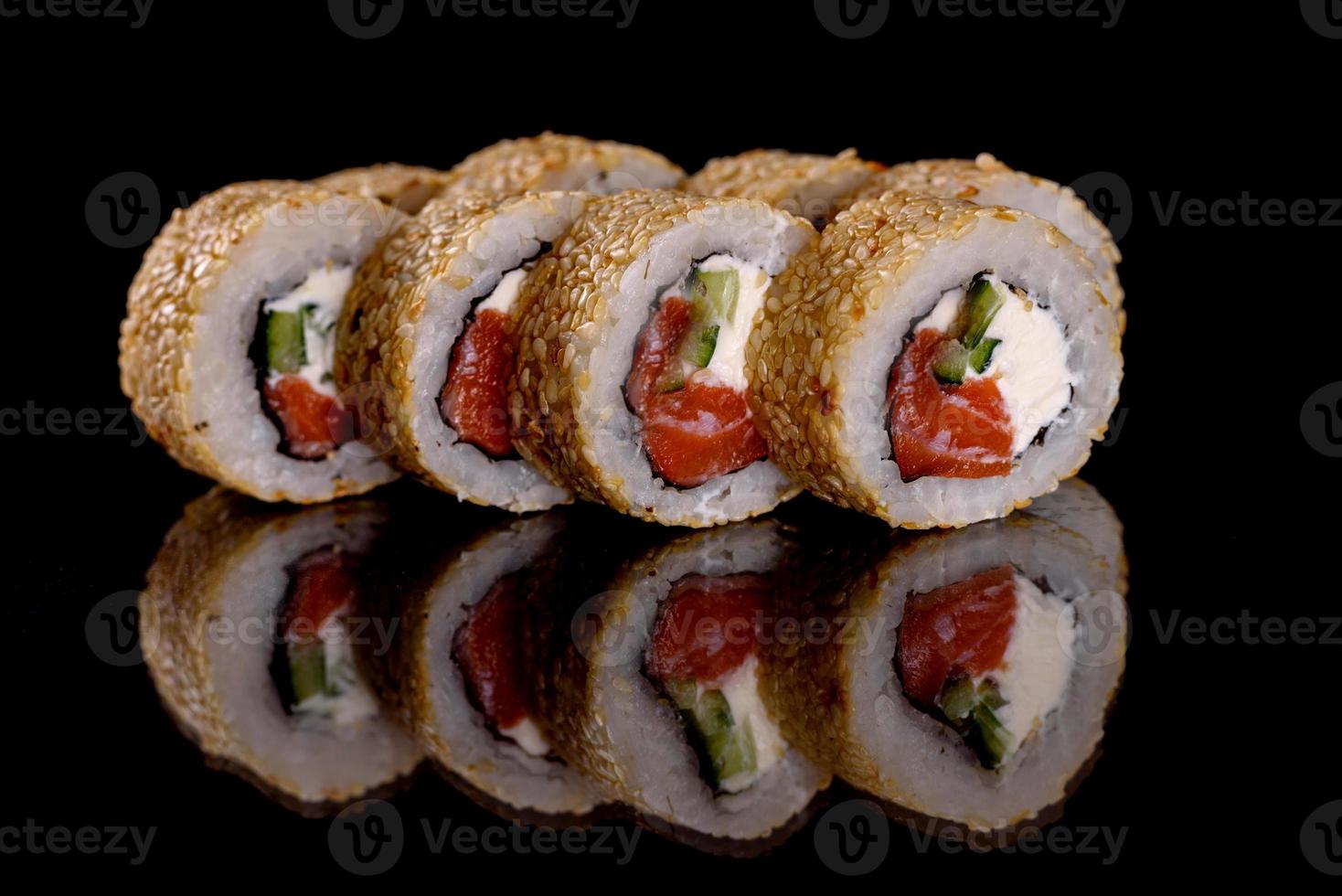 frescos deliciosos rolos de sushi bonitos em um fundo escuro foto