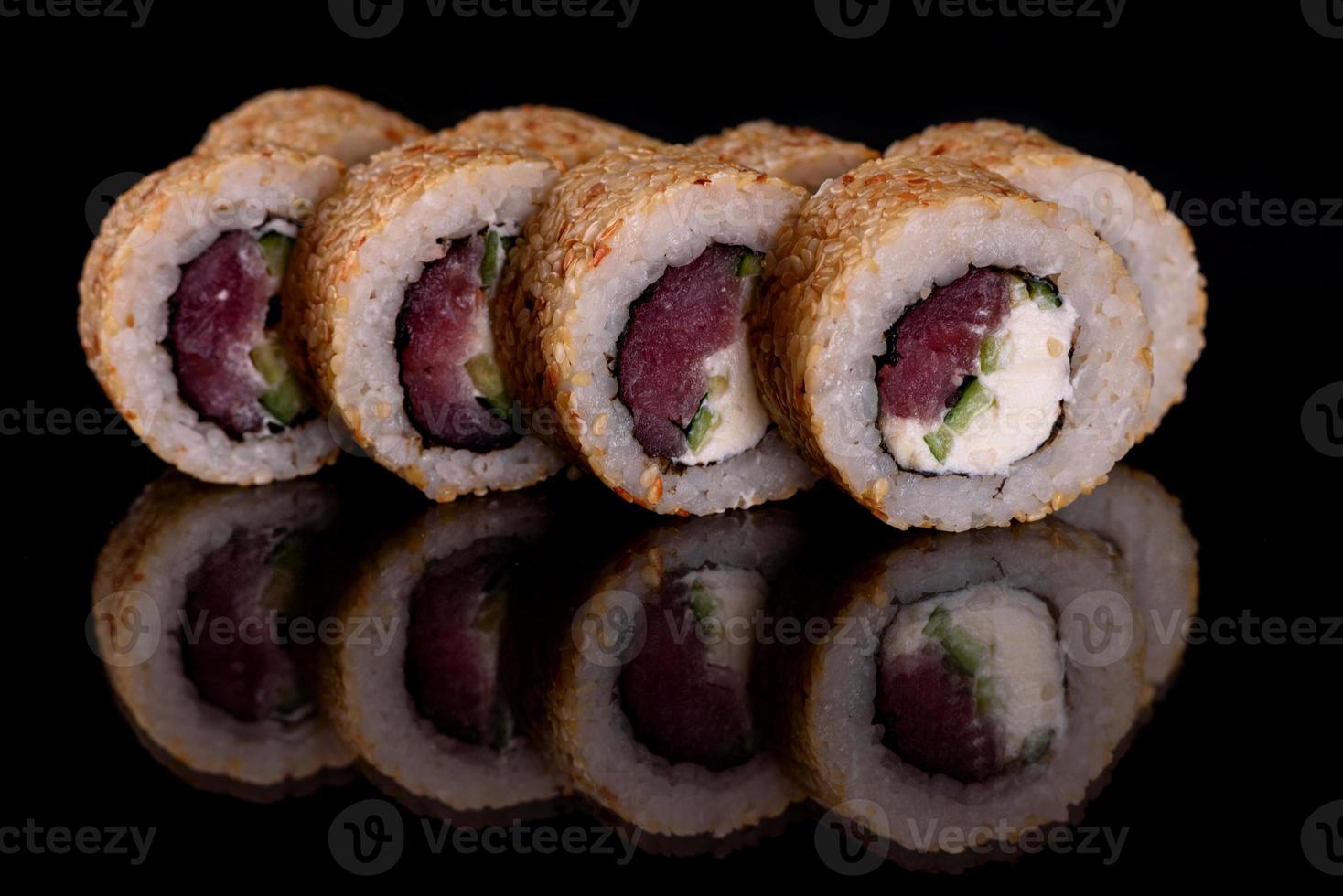 frescos deliciosos rolos de sushi bonitos em um fundo escuro foto