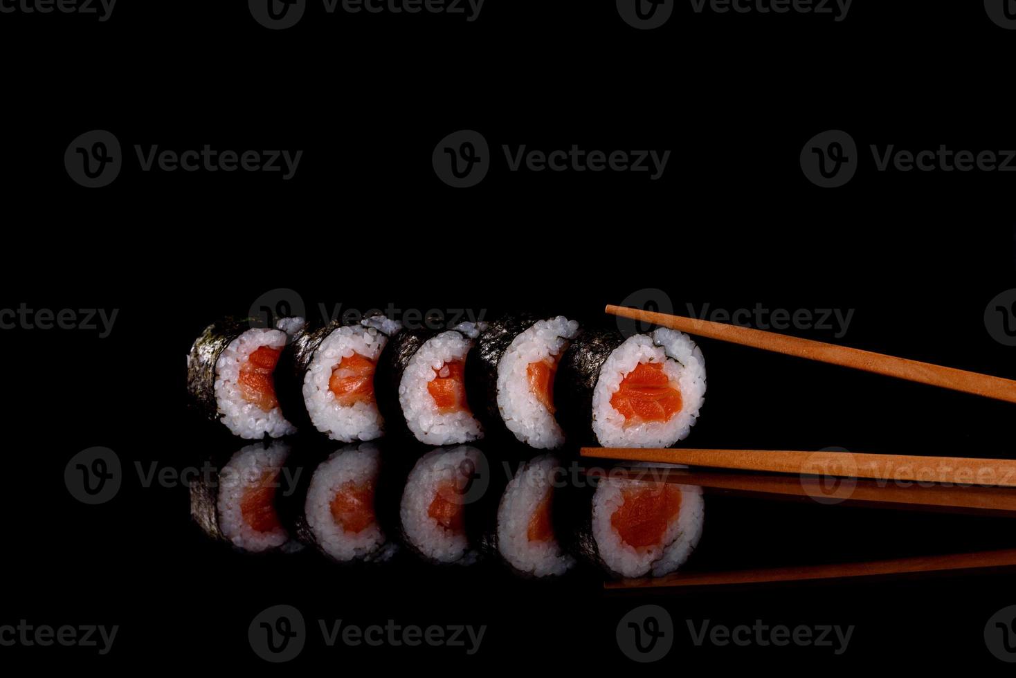 frescos deliciosos rolos de sushi bonitos em um fundo escuro foto