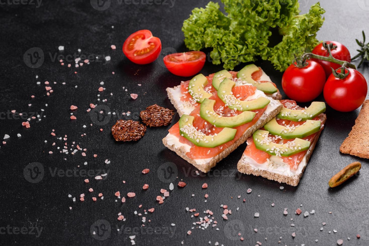 delicioso sanduíche fresco com peixe vermelho, manteiga, pão e abacate foto