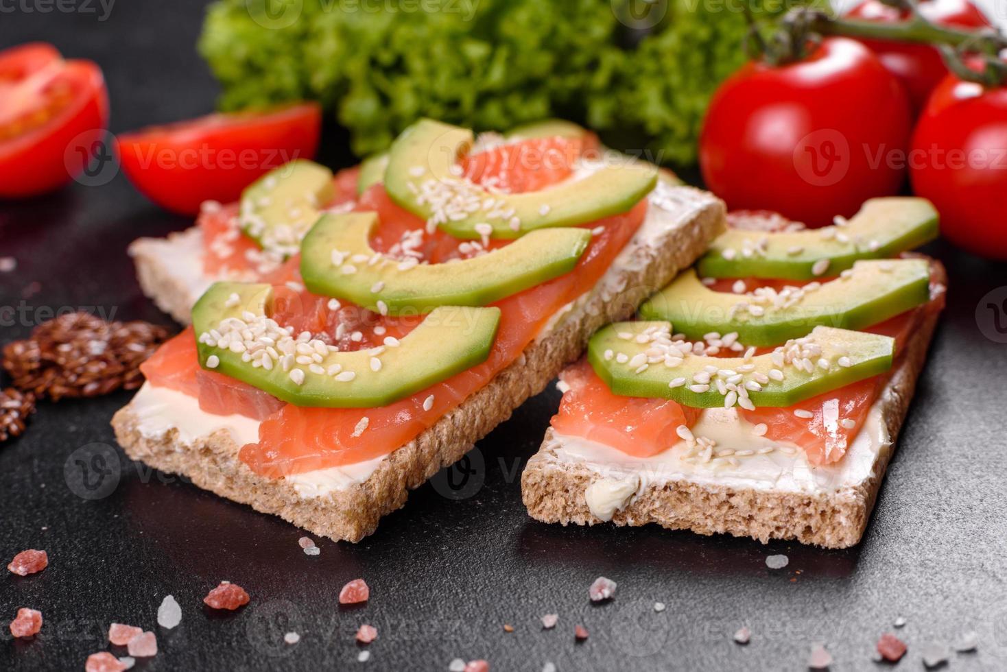 delicioso sanduíche fresco com peixe vermelho, manteiga, pão e abacate foto