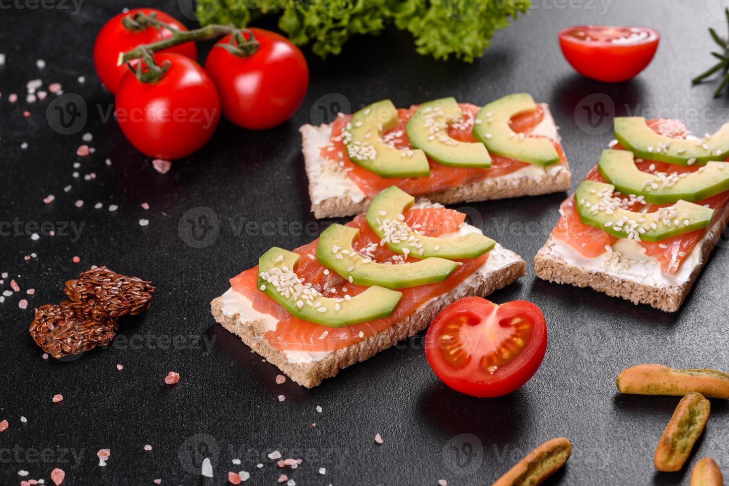 delicioso sanduíche fresco com peixe vermelho, manteiga, pão e abacate foto