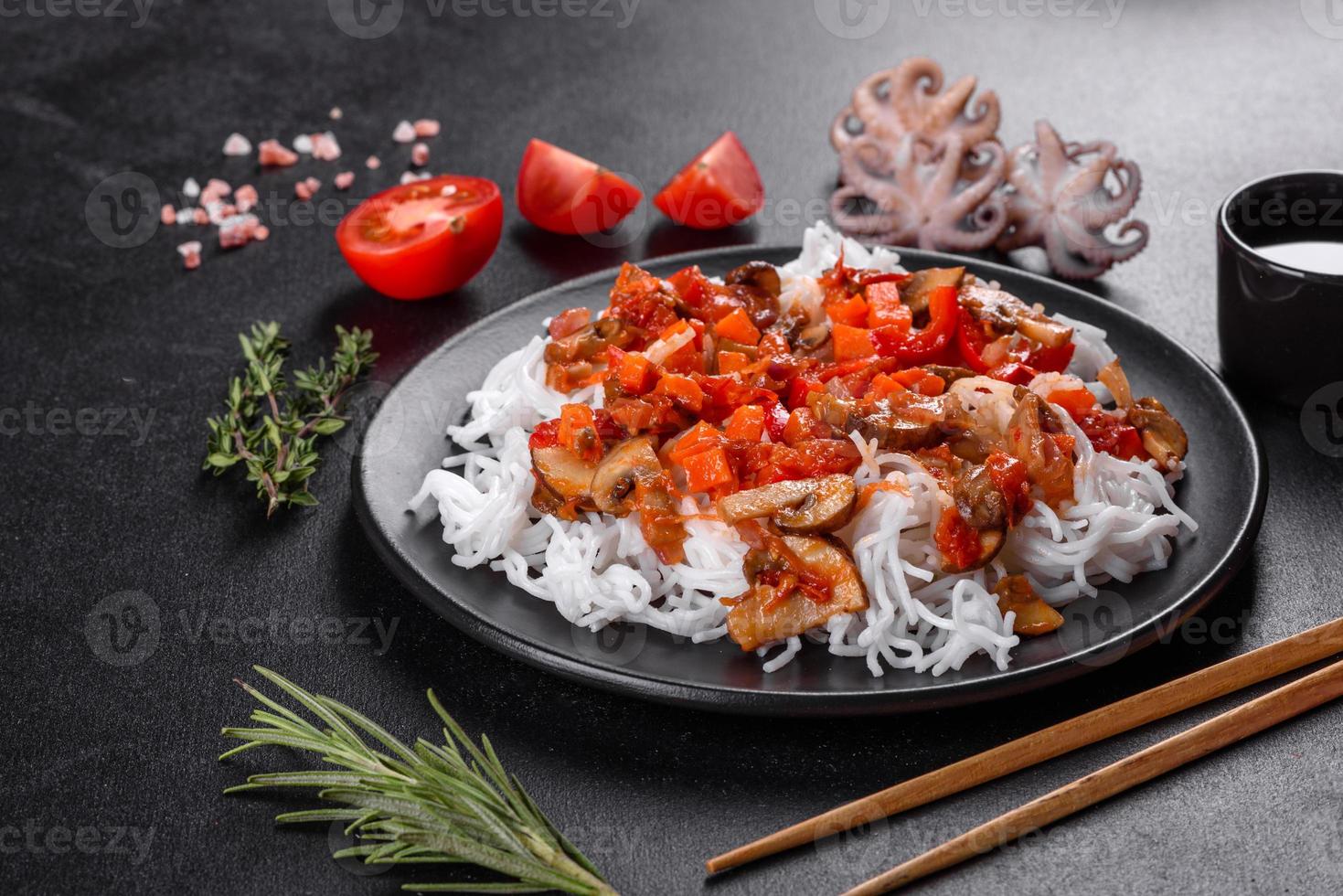 macarrão de arroz saboroso com tomate, pimenta vermelha, cogumelos e frutos do mar foto