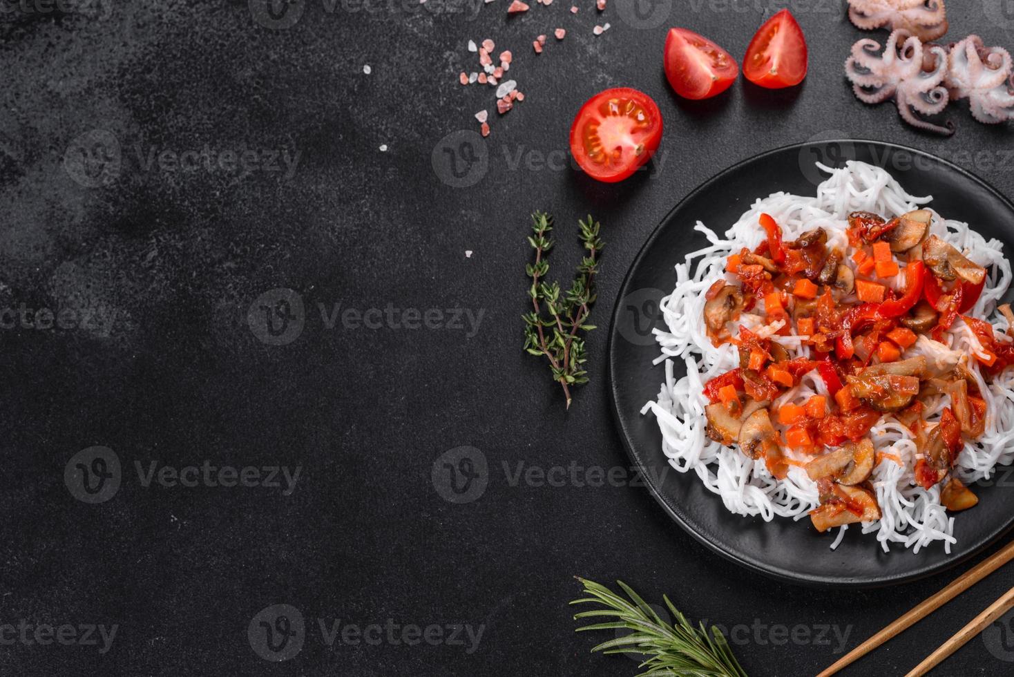 macarrão de arroz saboroso com tomate, pimenta vermelha, cogumelos e frutos do mar foto