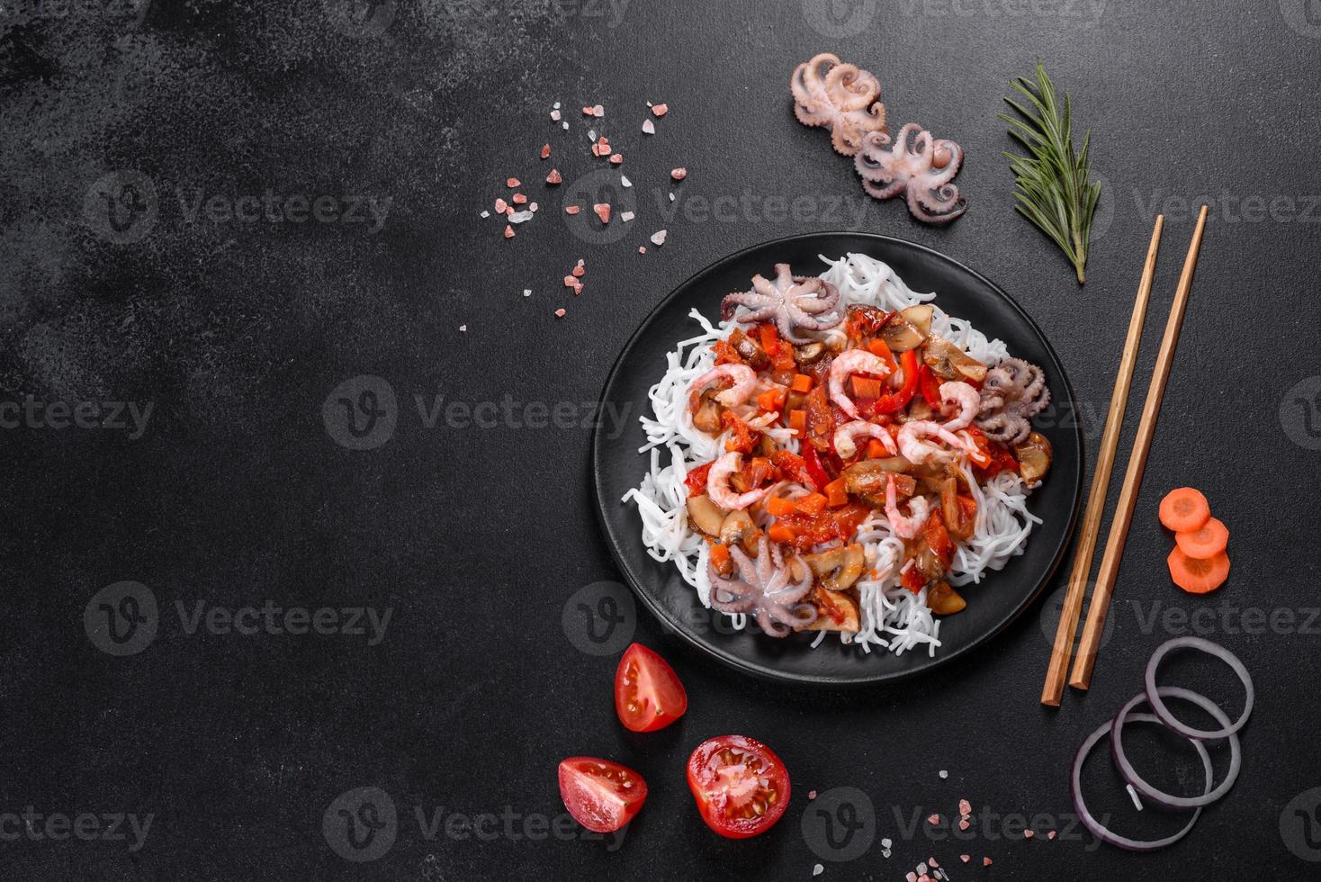 macarrão de arroz saboroso com tomate, pimenta vermelha, cogumelos e frutos do mar foto