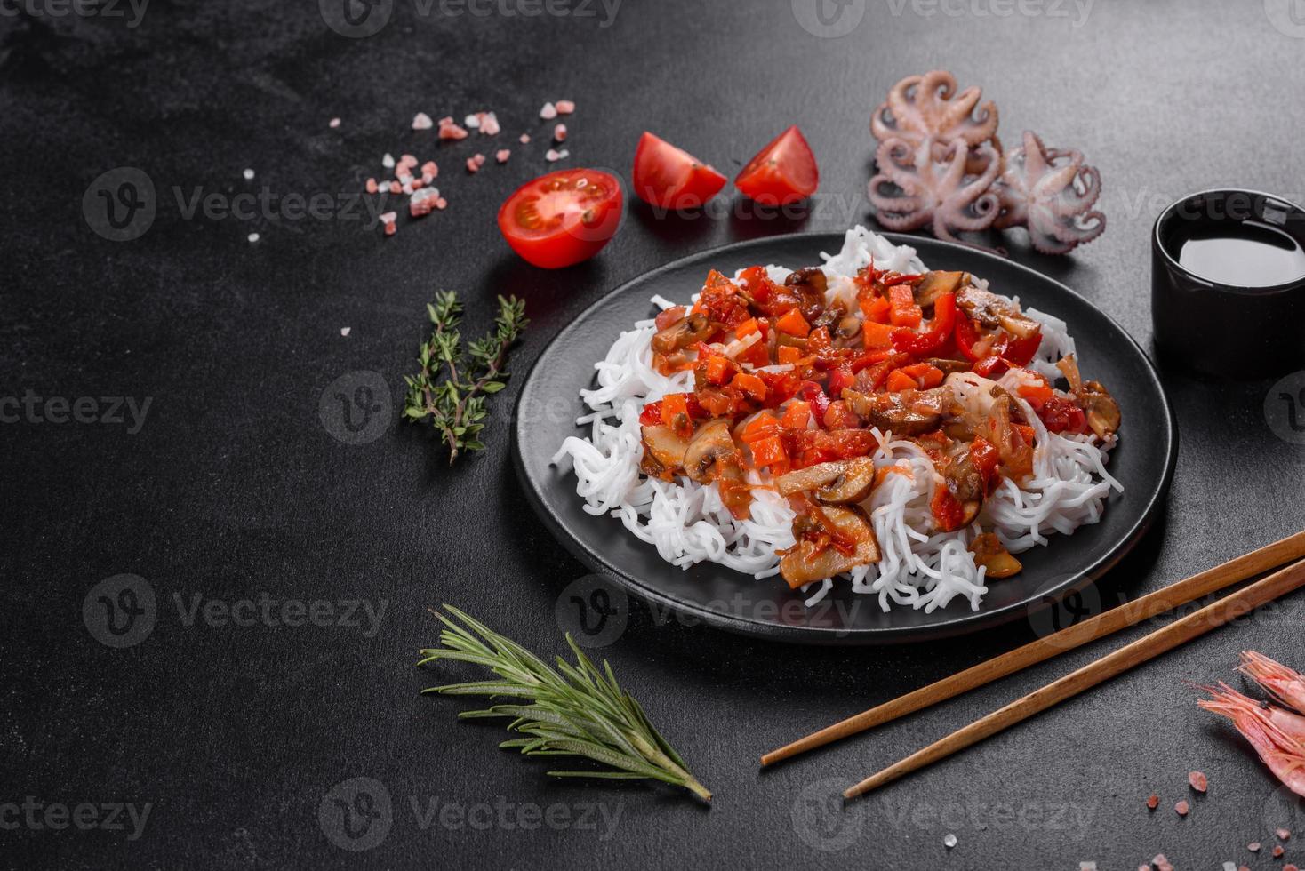 macarrão de arroz saboroso com tomate, pimenta vermelha, cogumelos e frutos do mar foto