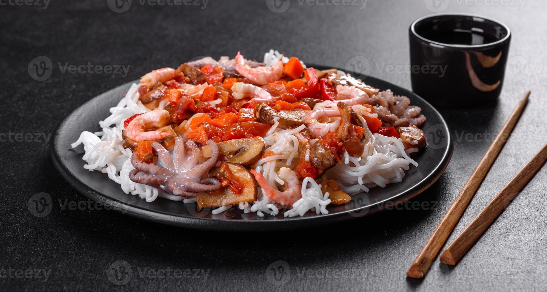 macarrão de arroz saboroso com tomate, pimenta vermelha, cogumelos e frutos do mar foto