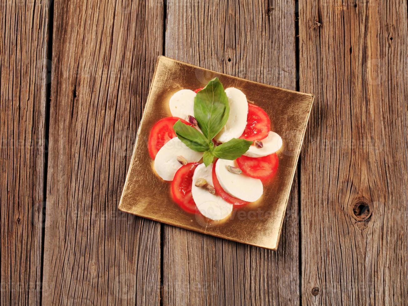 salada caprese - fatias de tomate fresco e queijo mussarela foto