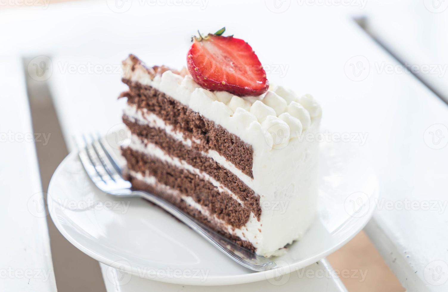 Bolo de baunilha e chocolate com morango no café foto