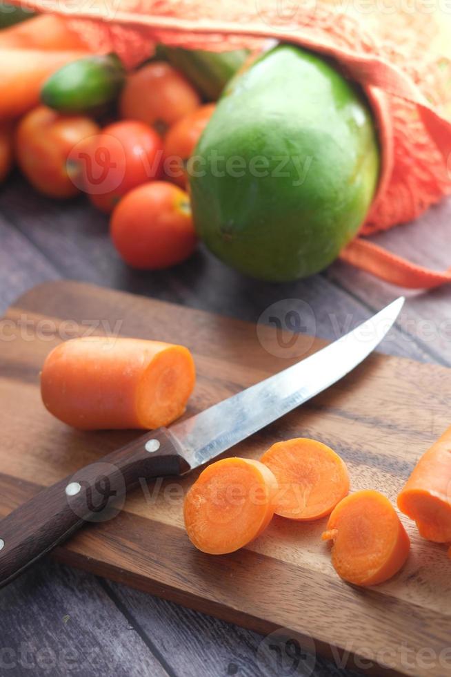 cenouras frescas na tábua de cortar na mesa foto
