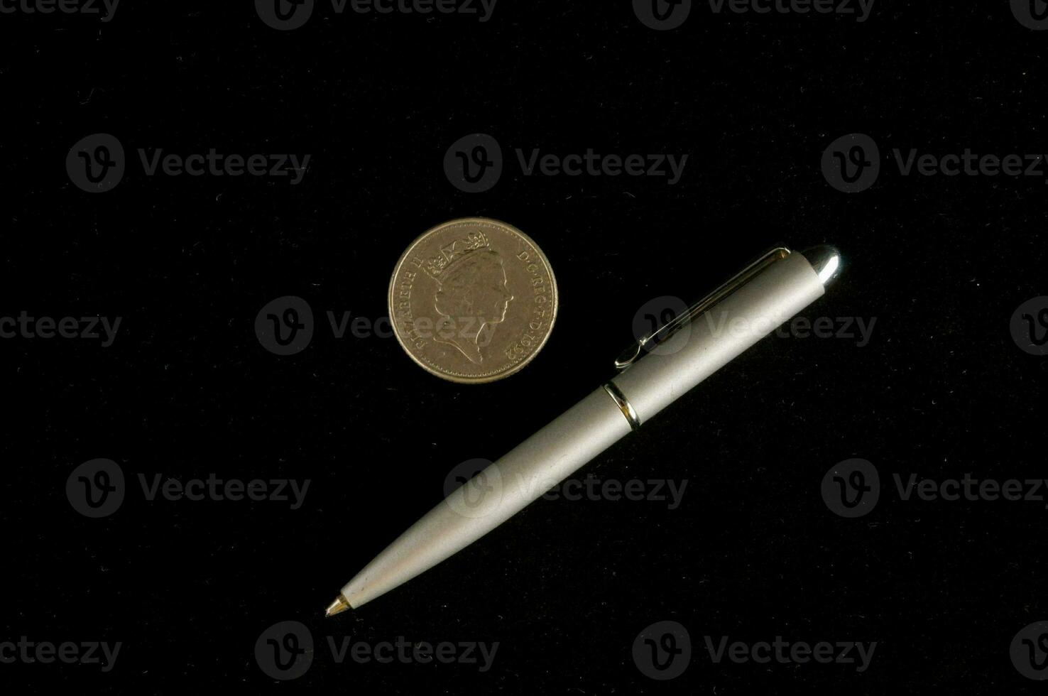 uma caneta e moeda em Preto fundo foto