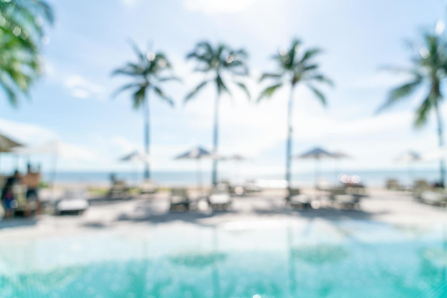 Resumo desfocar a piscina ao redor da piscina em um resort de hotel de luxo como plano de fundo - conceito de férias e férias foto