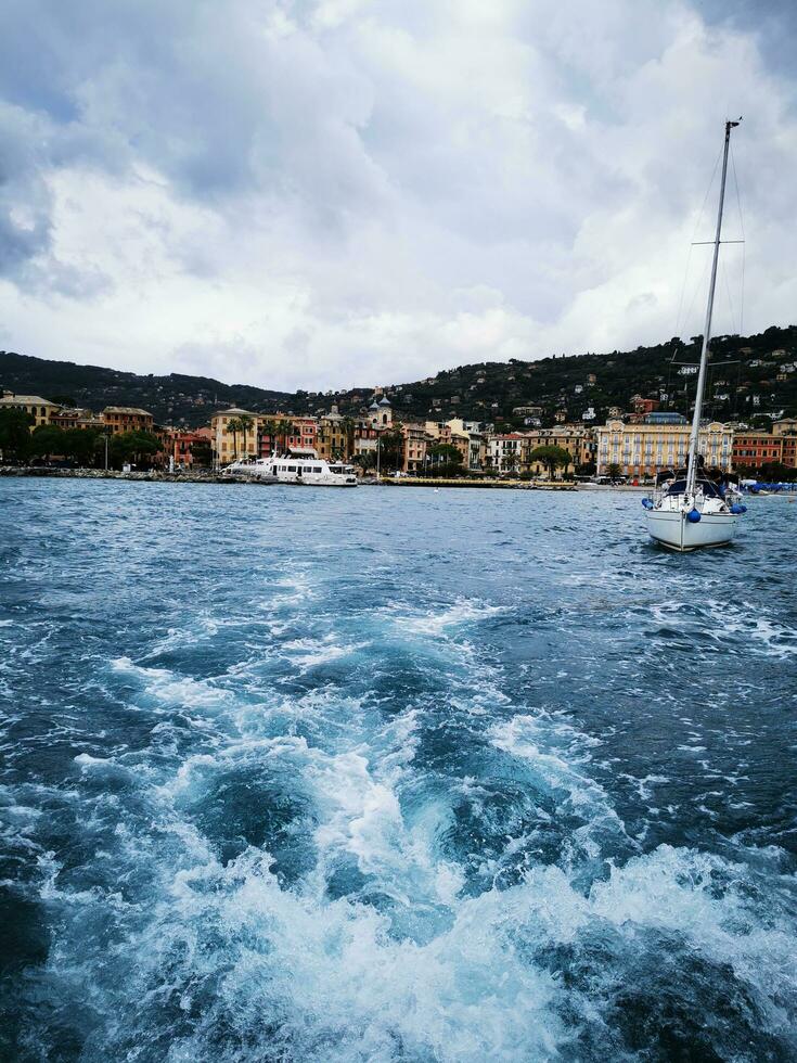 foto do uma barco a vela Navegando perto uma pitoresco costeiro Cidade