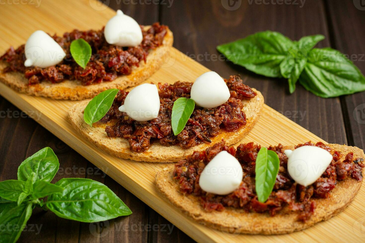 bruschetta com tomate seco, mussarela, alho e azeite. sanduíche de cozinha italiana tradicional feita de ciabatta grelhado. antipasti foto