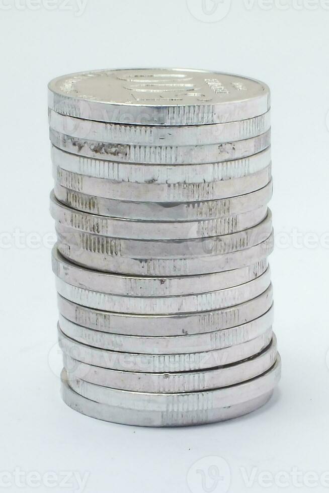 pilha do indonésio rupia moedas em uma branco fundo foto