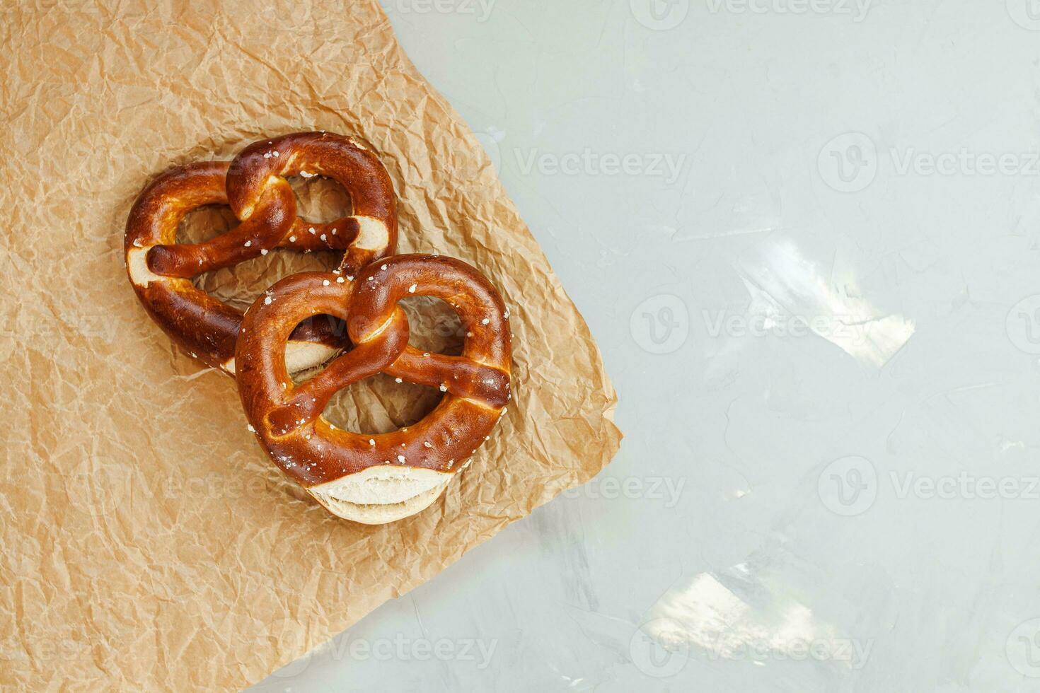 dois caseiro recentemente cozido suave salgadinhos em Castanho papel. tradicional bávaro pretzel para Festival de outubro. topo visualizar, cópia de espaço foto