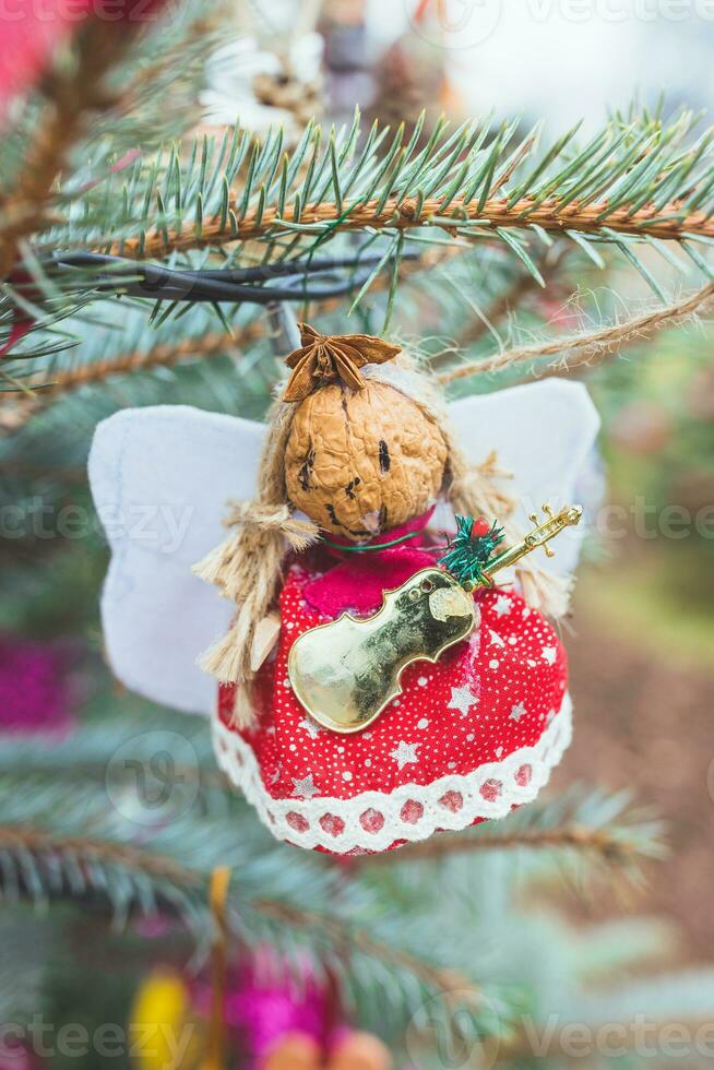 feito à mão natural noz Natal decoração em Natal árvore. Natal anjo com asas Estrela e violino violoncelo. faça você mesmo Ideias para crianças. ambiente, reuso, reutilização conceito. seletivo foco foto