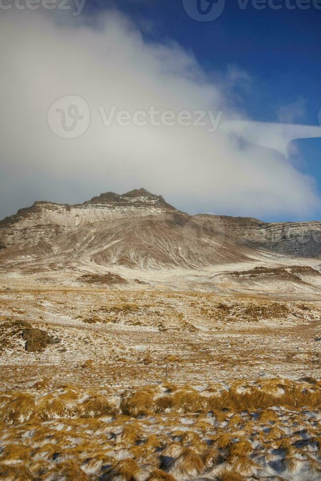 gelado prados e montanha correntes coberto dentro neve perto islandês beira da estrada pastagens, nórdico colinas e terras. ártico natureza contendo congeladas Campos e Nevado montanhas dentro Islândia. foto