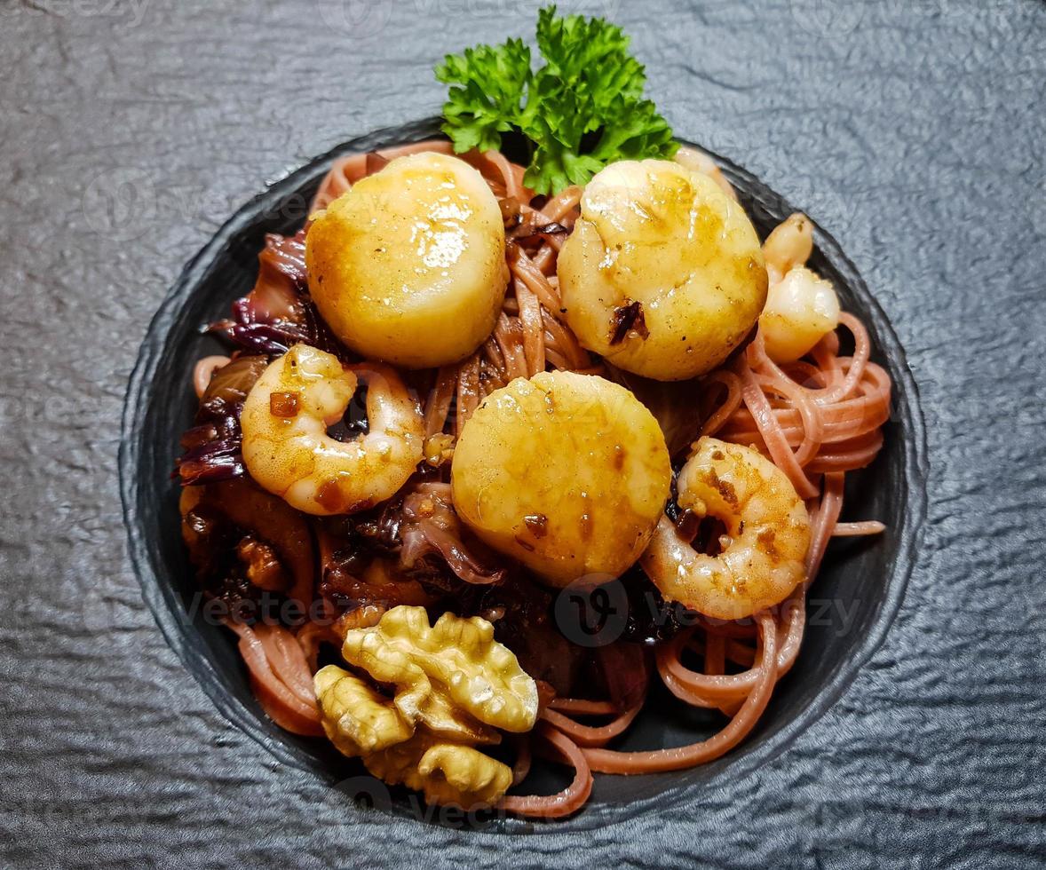 vieiras com ervas e especiarias de macarrão de linguine vermelho foto