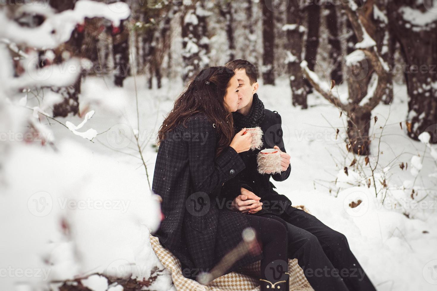 um rapaz e uma rapariga com roupas e lenços numa caminhada na neve foto