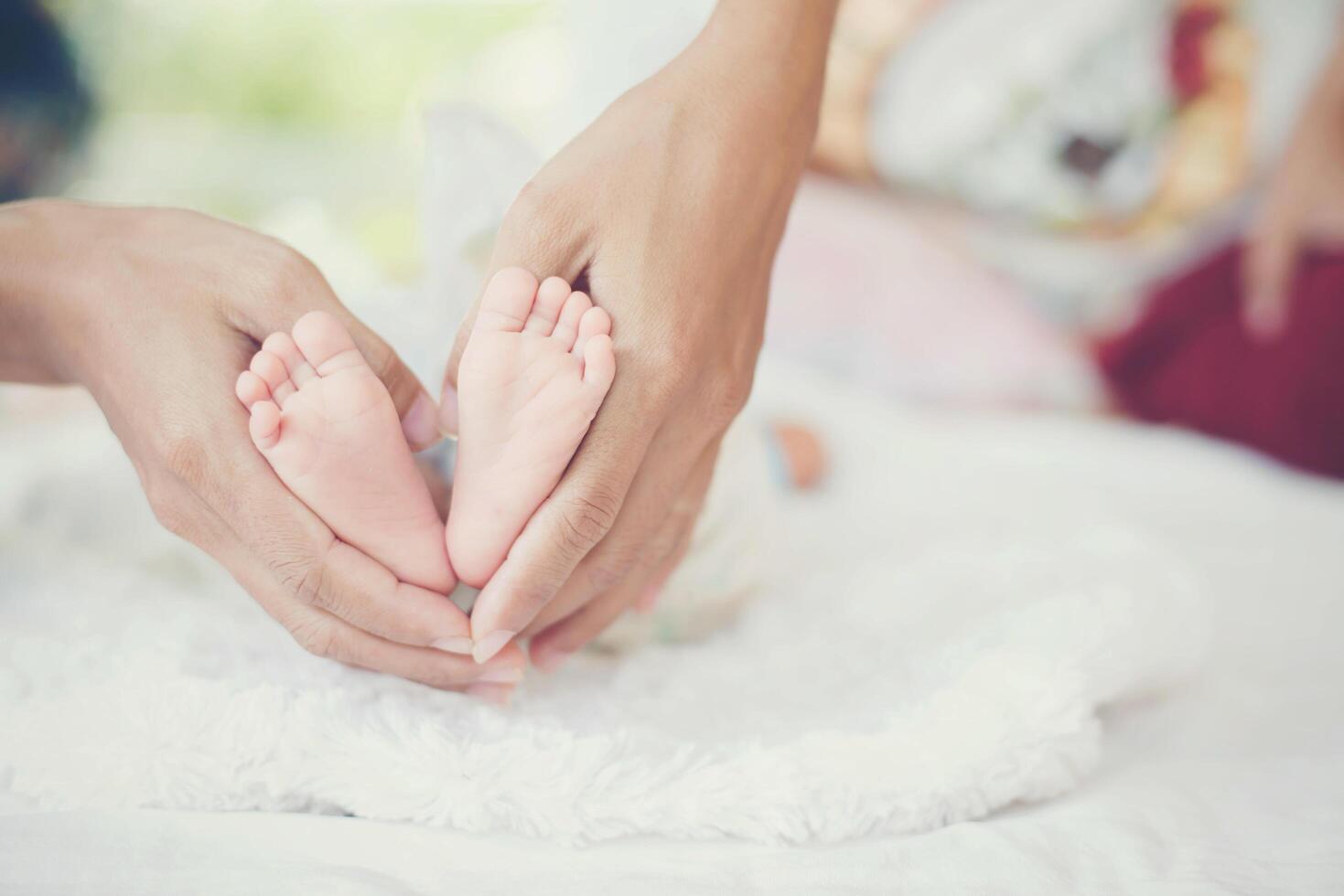 pés do bebê newbron nas mãos da mãe. foto