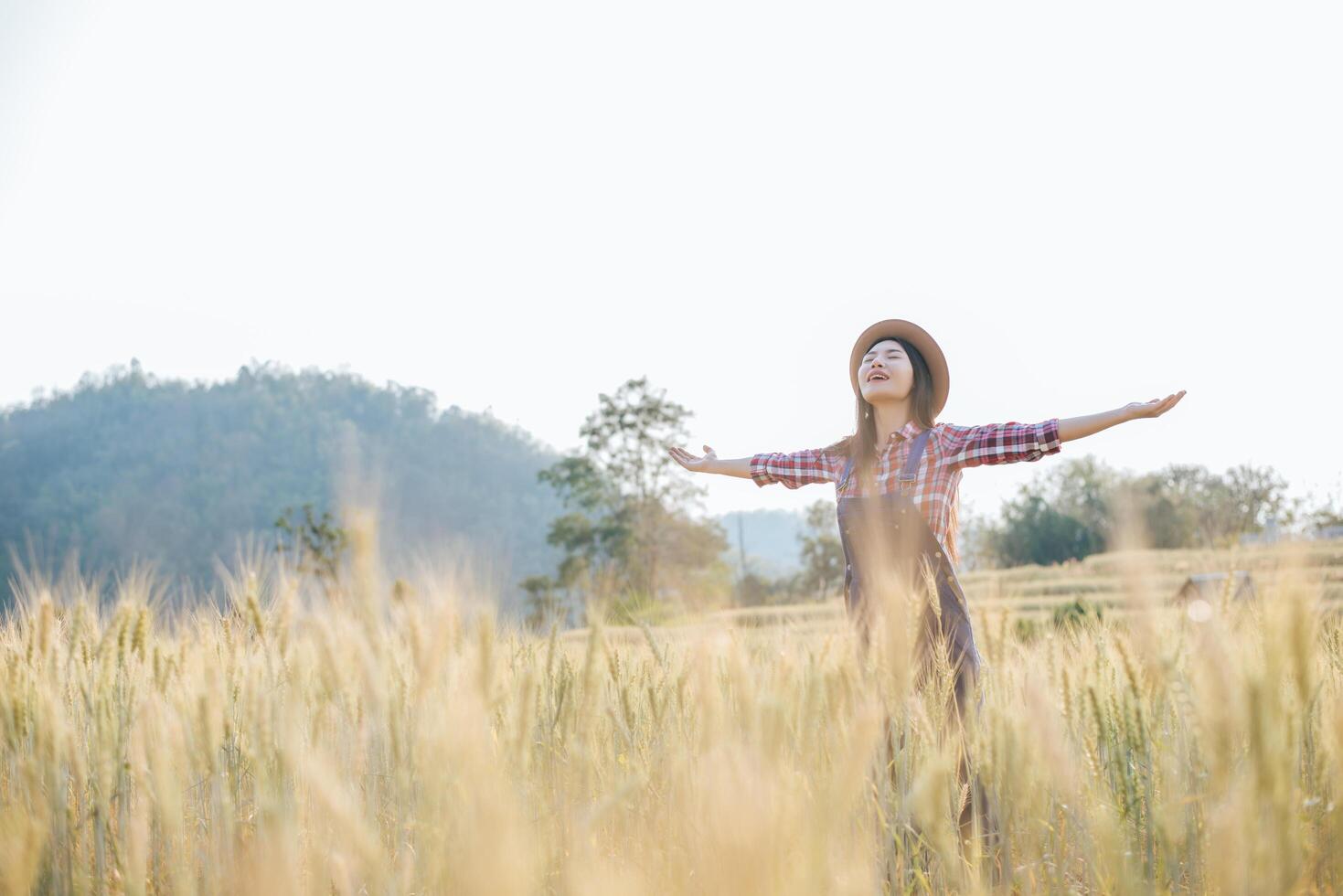 mulher agricultora com época de colheita do campo de cevada foto