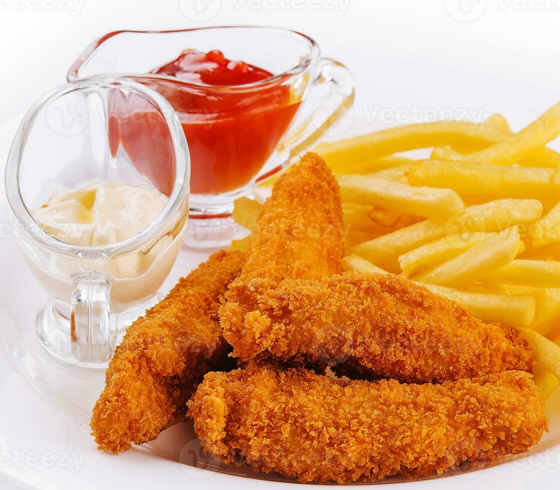 frango pepitas com francês fritas em prato foto