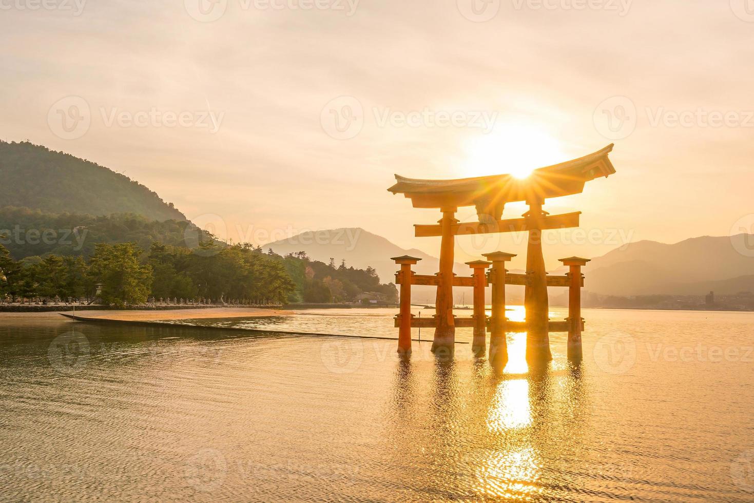 o portão flutuante do santuário itsukushima ao pôr do sol foto