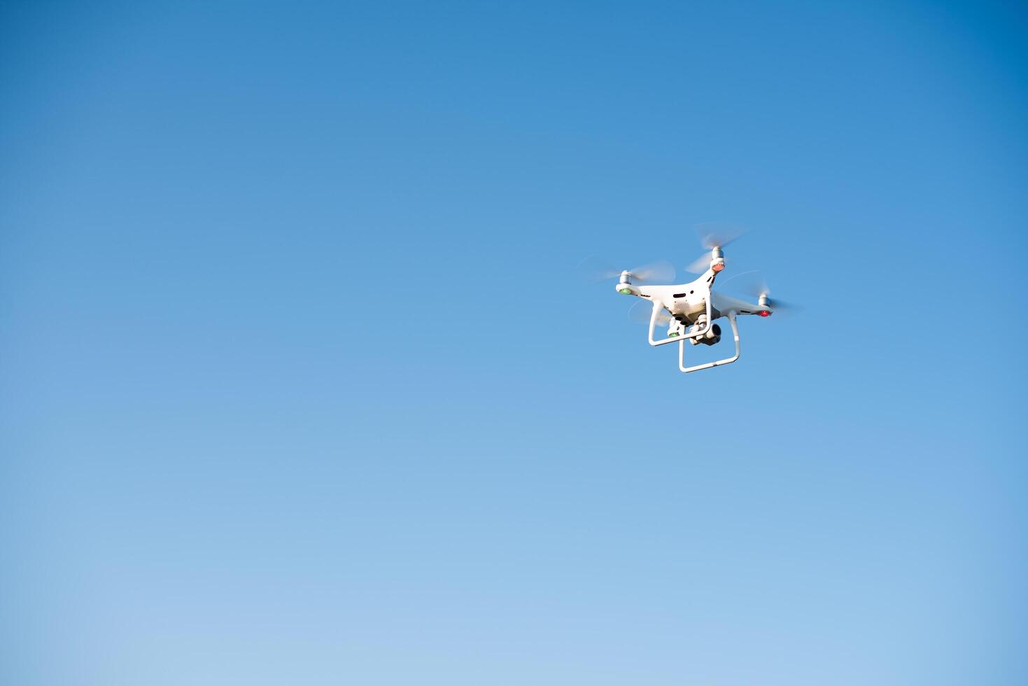 drone branco voa no céu gravando um vídeo foto