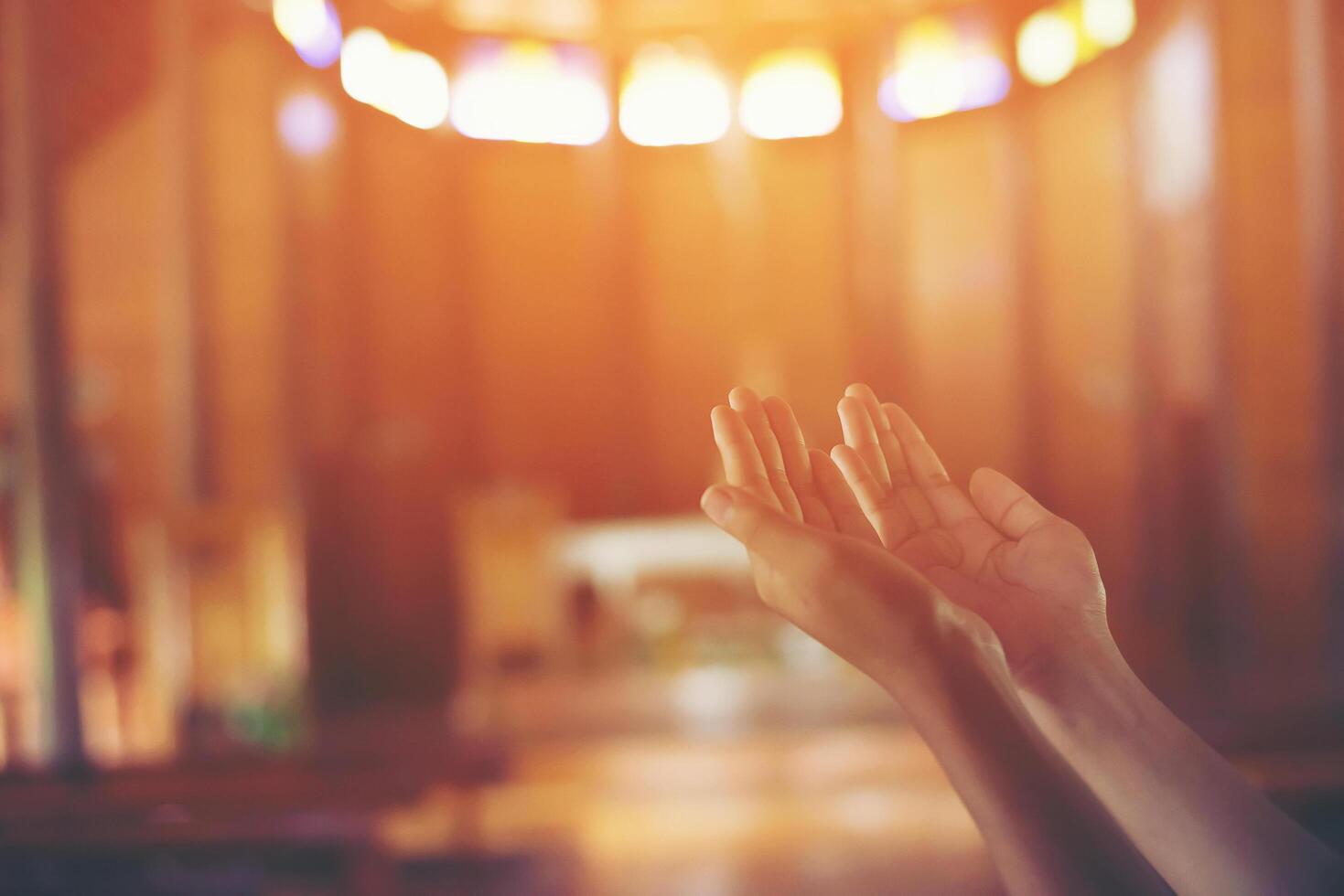 as mãos de uma jovem em oração na igreja de cristo foto