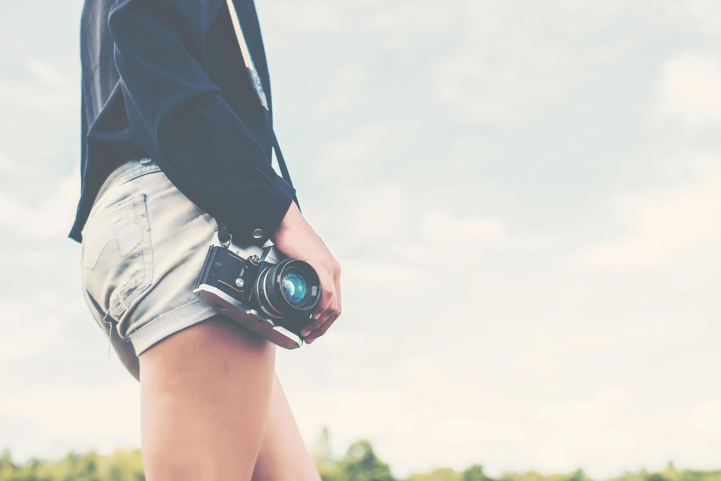 Fotógrafa de belas mulheres segurando uma câmera retro foto