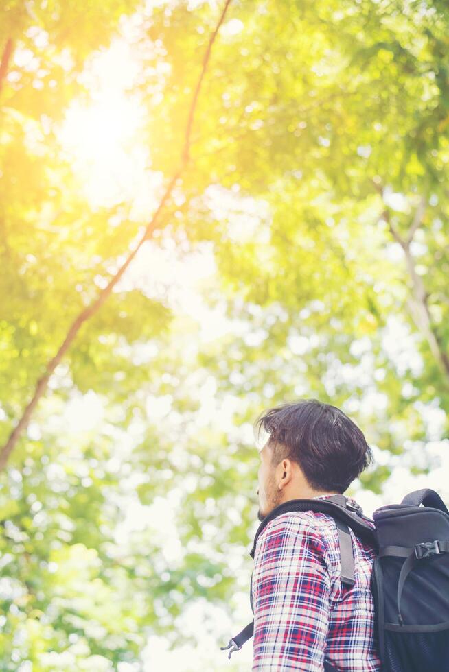 homem viajante moderno olhando para a natureza aproveitando o clima fresco foto