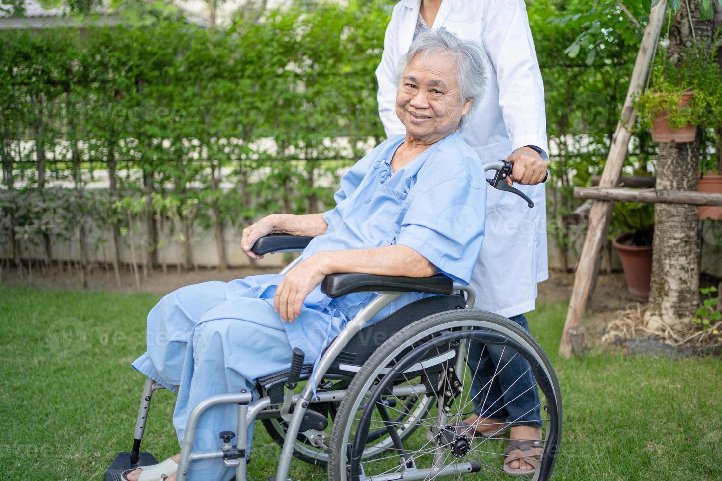 médico, ajuda e cuidados, paciente asiática idosa sentada na cadeira de rodas foto