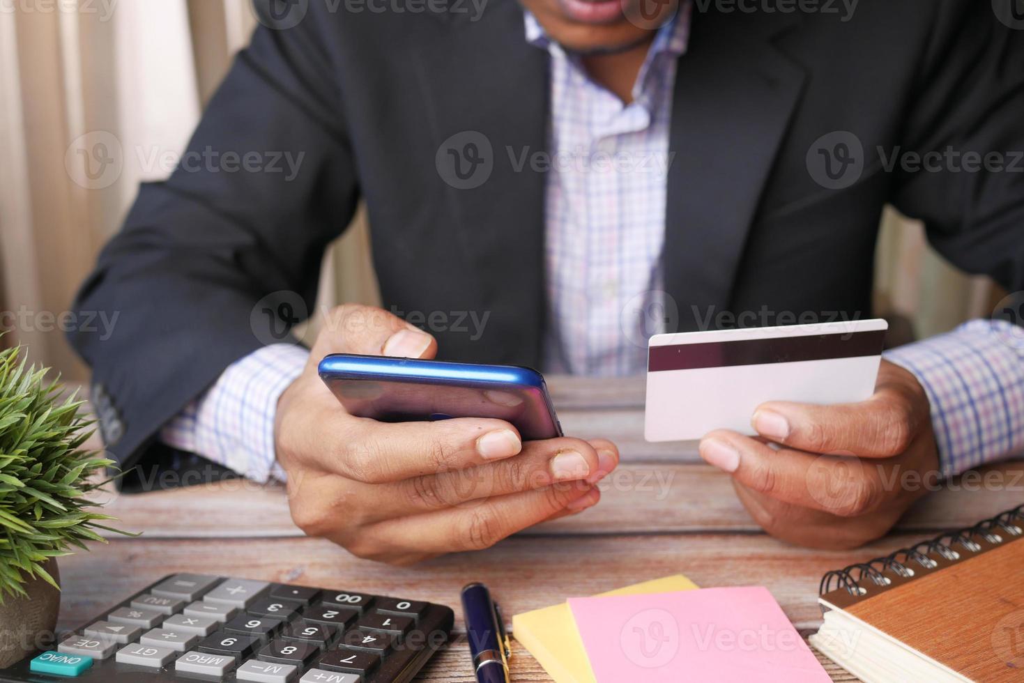 jovem colocando detalhes de cartão de crédito em telefone inteligente foto
