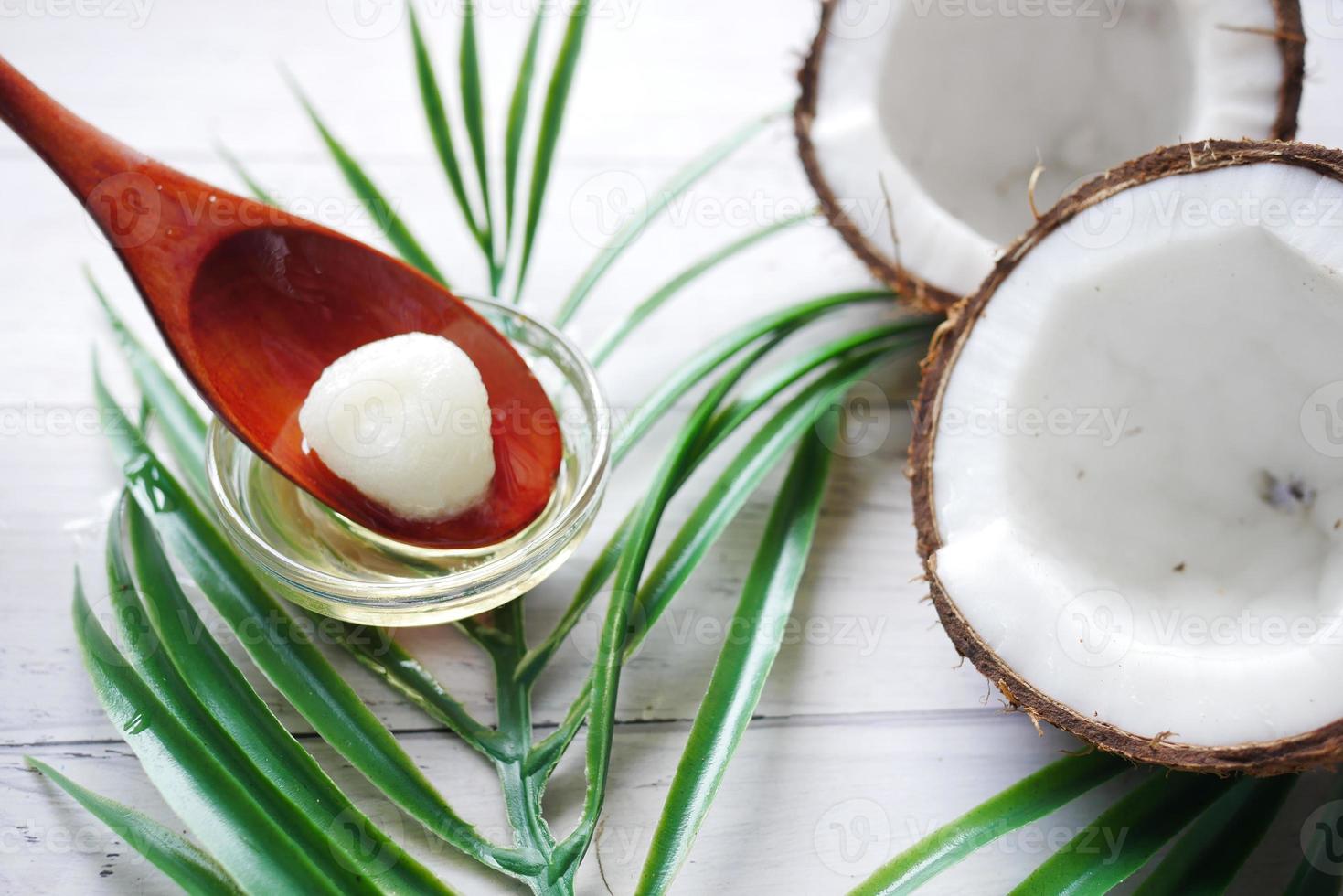 fatia de coco fresco e óleo na colher na mesa foto