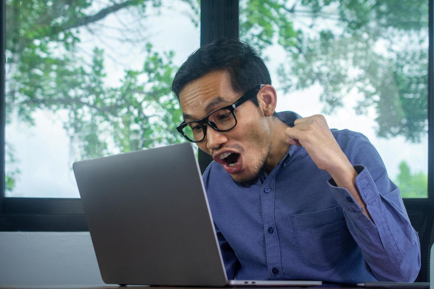 homem feliz e animado com lucro negociando online, empresário usando o computador foto