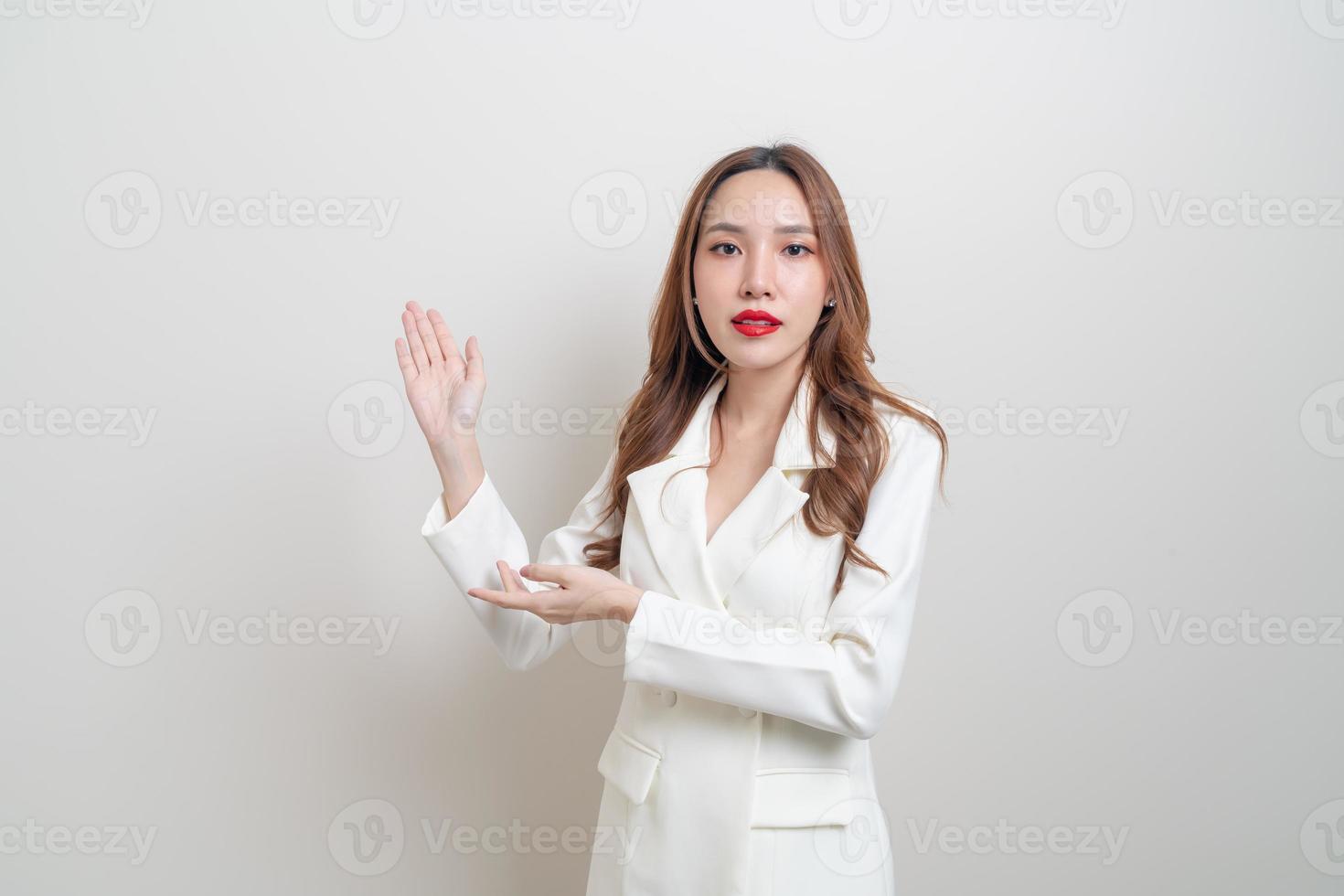 retrato de uma bela mulher de negócios asiáticos com a mão apresentando ou apontando no fundo branco foto