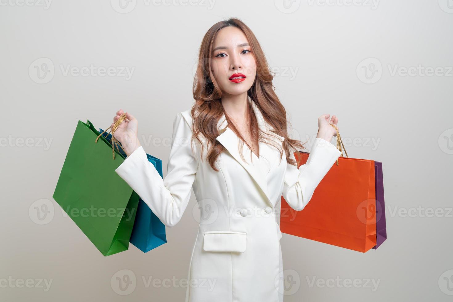 retrato de uma linda mulher asiática segurando uma sacola de compras no fundo branco foto